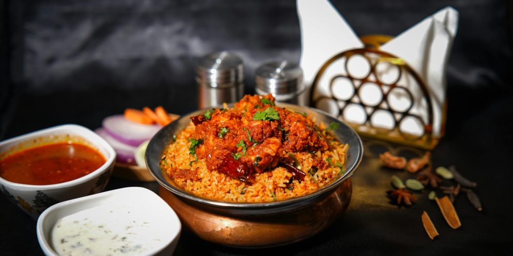 Mouth-watering chicken biryani with spices, sauces, and garnishes, perfect for food lovers.